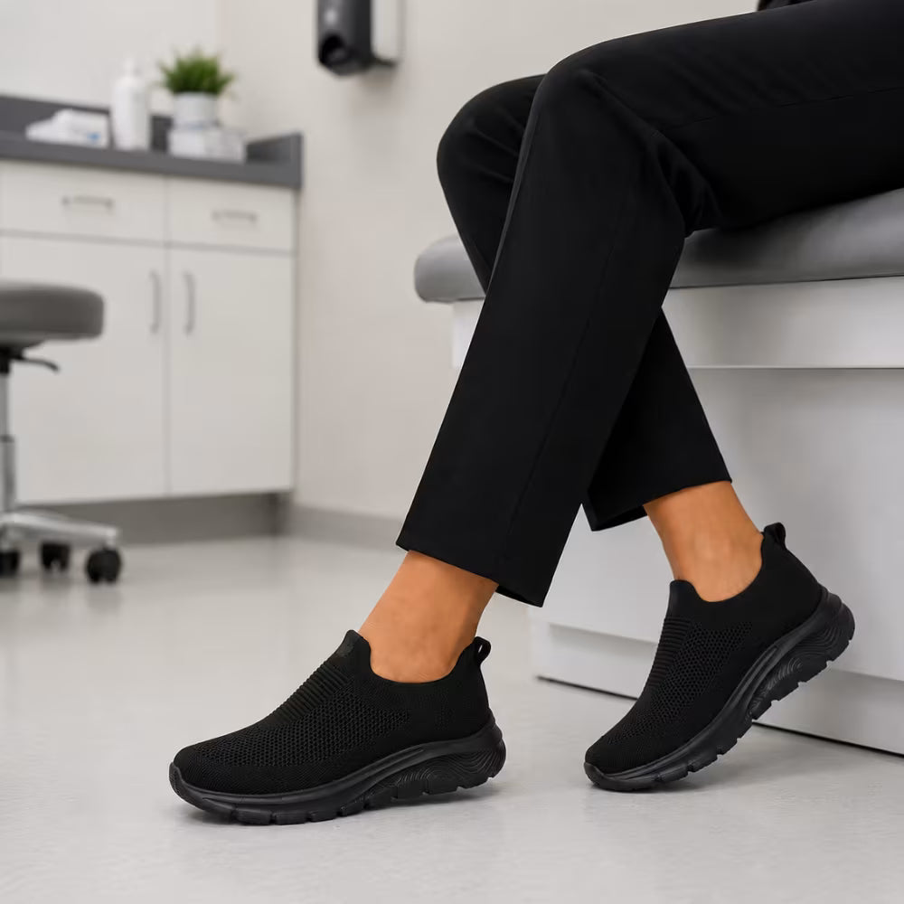 Black knit slip-in sneakers on feet with cushioned flexible sole